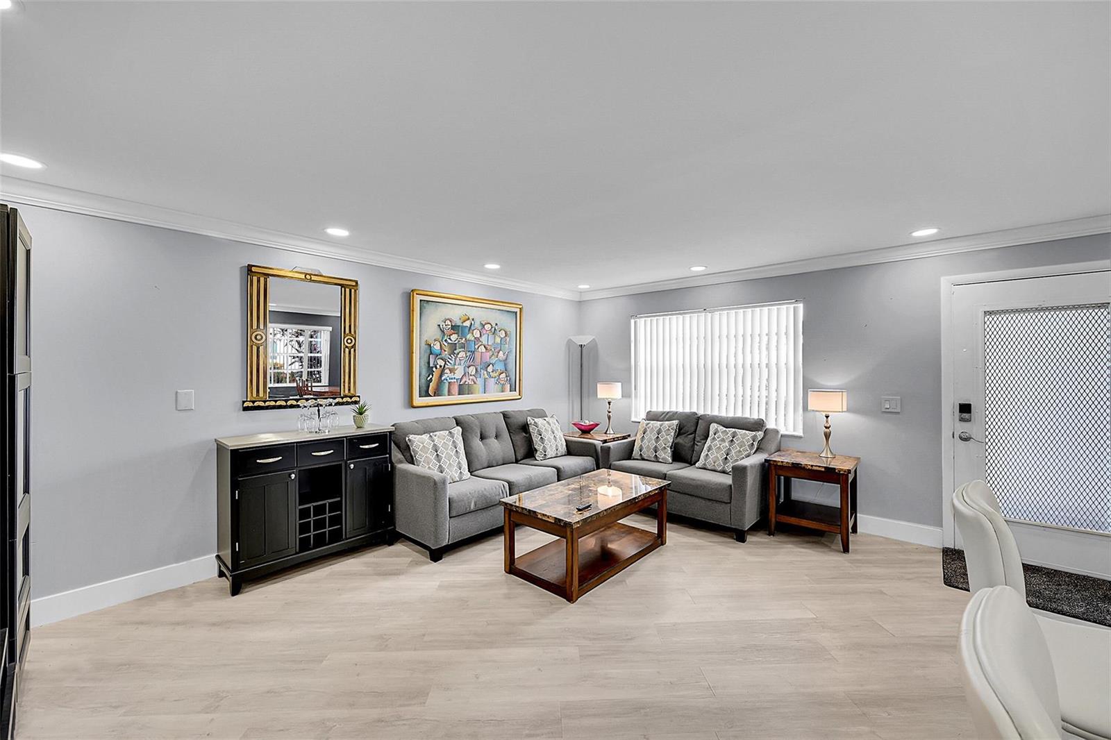 A living room features gray walls, light wood flooring, a sectional sofa, and a sideboard — 964 Normandy Trail # U, Delray Beach FL 33484, DELRAY BEACH, FL
