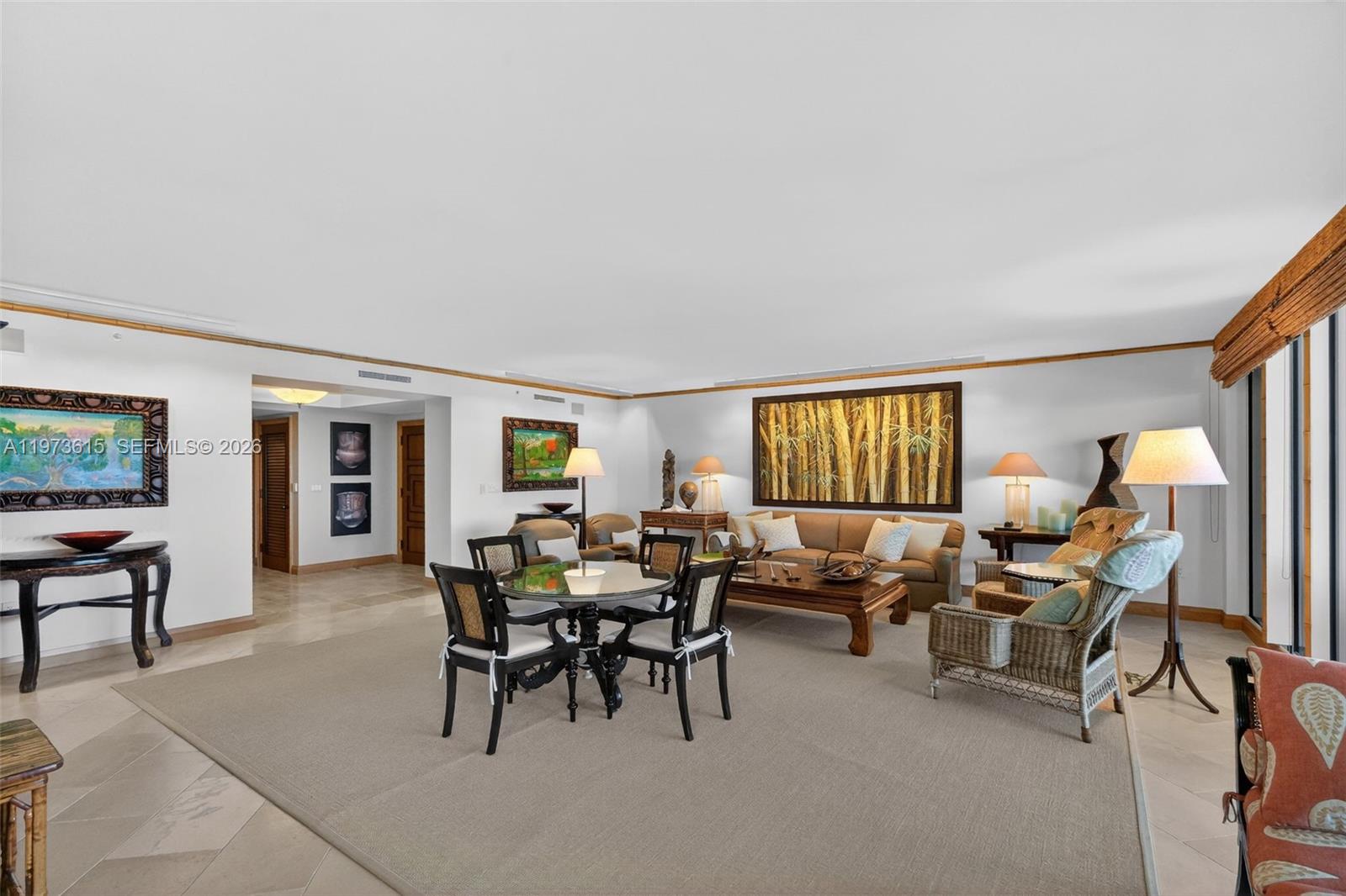 A spacious living and dining area features neutral tile floors, area rugs, and bamboo-style decor — 430 Grand Bay Dr # 801, Key Biscayne FL 33149, KEY BISCAYNE, FL