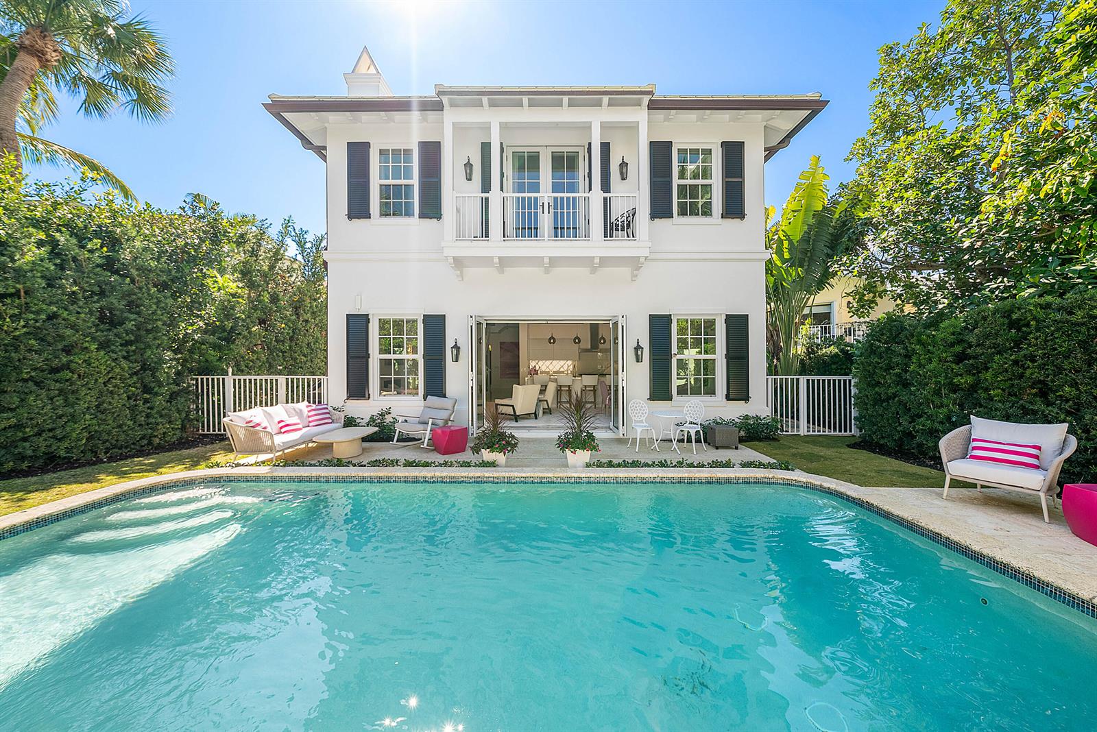 A two-story white house with black shutters overlooks a backyard swimming pool and patio — 157 Peruvian Avenue, Palm Beach FL 33480, PALM BEACH, FL
