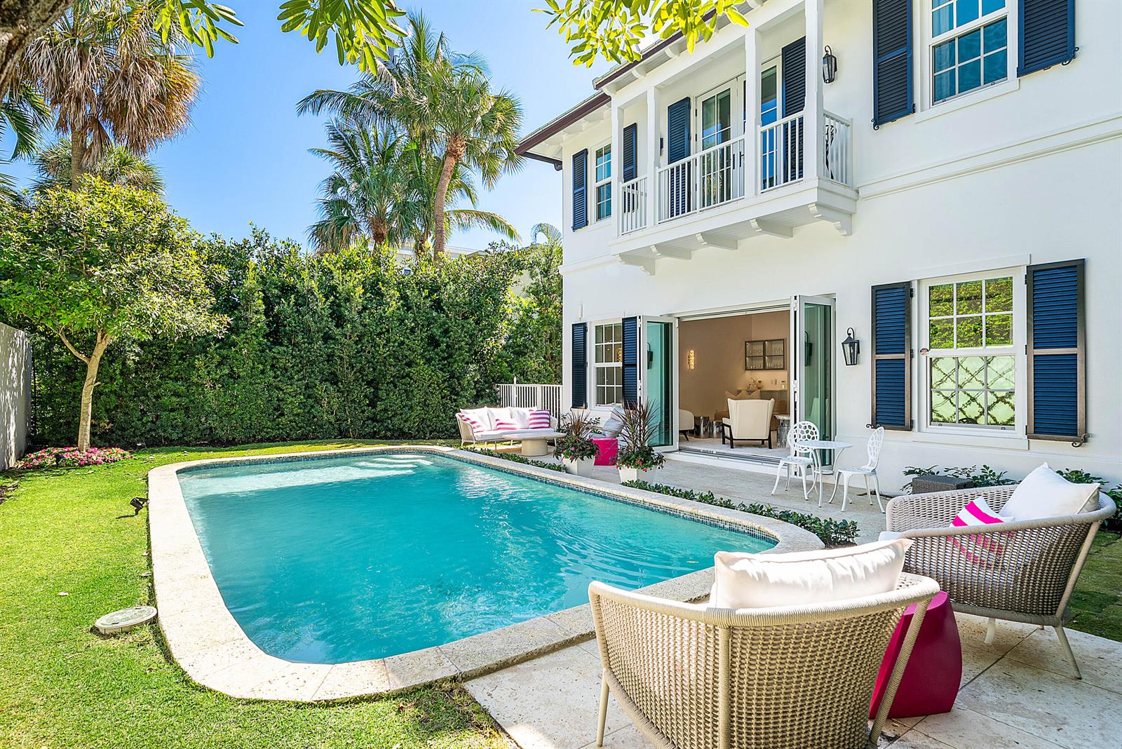A white two-story house with blue shutters overlooks a swimming pool and patio area — 157 Peruvian Avenue, Palm Beach FL 33480, PALM BEACH, FL