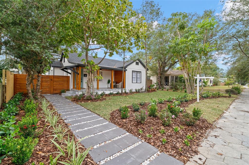 A white house with a wooden porch and a modern stone walkway in the front yard — 4536 1ST AVENUE N, ST PETERSBURG, FL