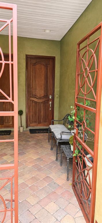 A gated entryway features a brick-paved patio, a wooden door, and a metal bench — 4907 BAYSHORE BOULEVARD UNIT 103, TAMPA, FL