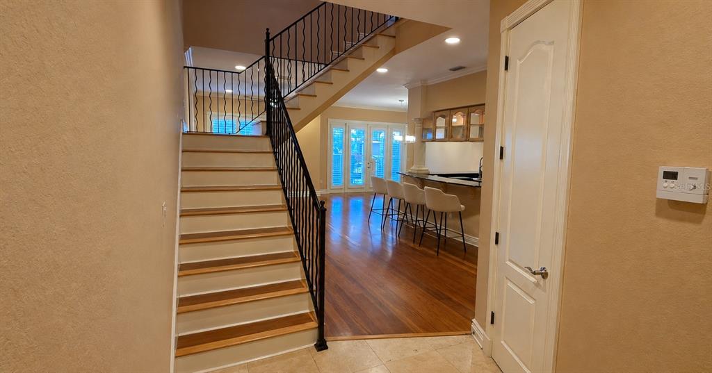 A staircase with a black metal railing leads to an upper level near a kitchen — 4907 BAYSHORE BOULEVARD UNIT 103, TAMPA, FL