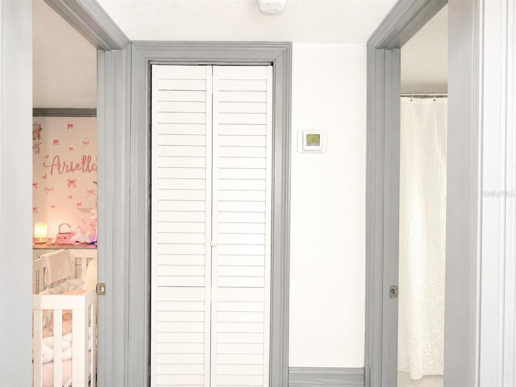 A hallway features a central louvered closet door flanked by a bedroom and a bathroom — 6301 58TH STREET N UNIT 402, PINELLAS PARK, FL