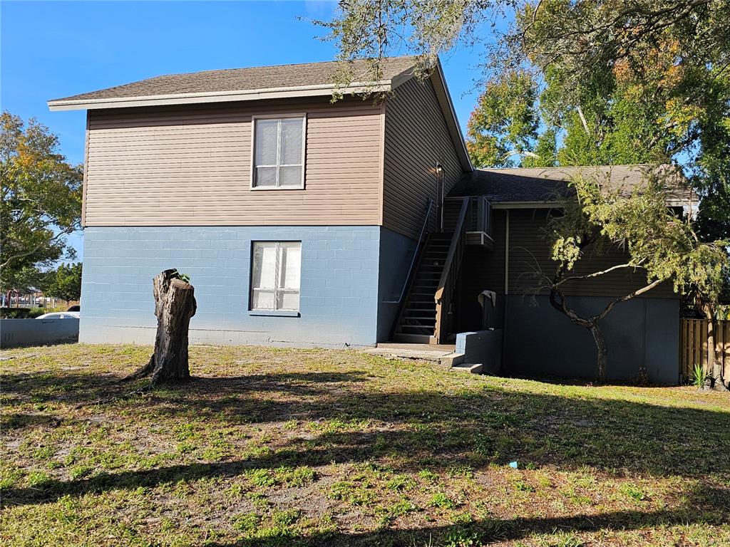 A two-story building features a blue concrete block lower level and brown siding above — 7611 PAULA DRIVE UNIT 5, TAMPA, FL