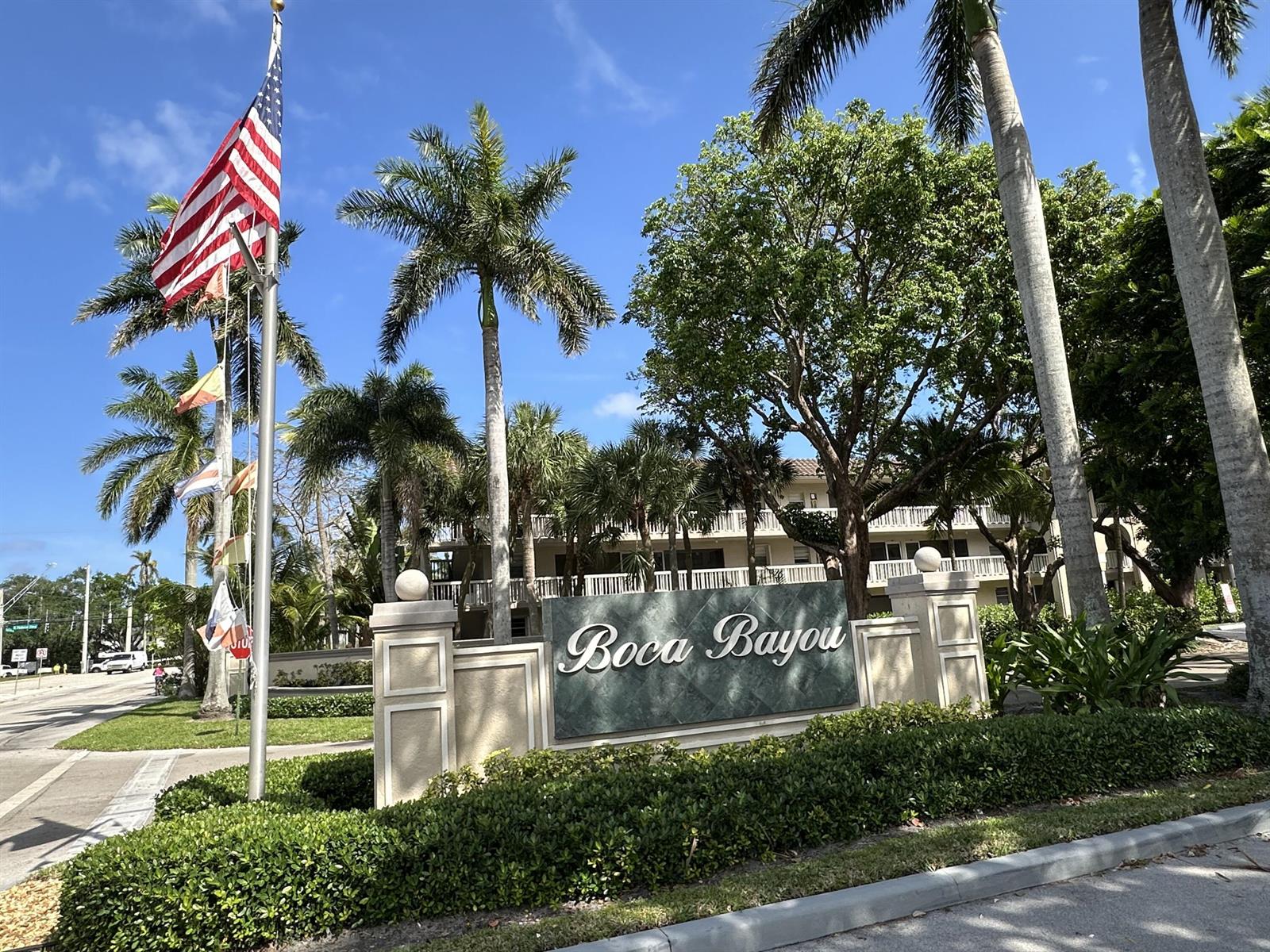 A sign for Boca Bayou stands in front of palm trees and a multi-story building — 27 Royal Palm Way # 406, Boca Raton FL 33432, BOCA RATON, FL
