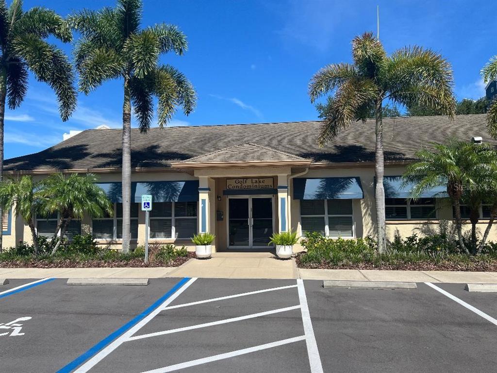 The exterior of the Golf Lake Condominiums building features a tan facade and palm trees — 960 STARKEY ROAD UNIT 10305, LARGO, FL