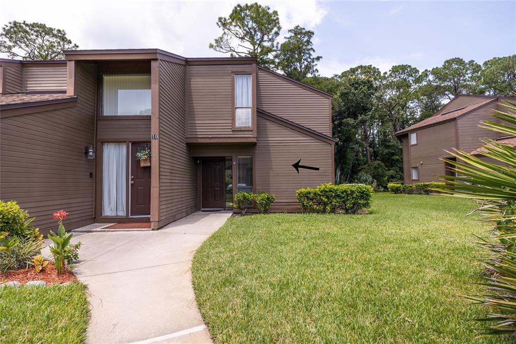 A brown, two-story townhouse exterior with a concrete walkway and a small front lawn — 9 SOUTHBURY COURT UNIT 9, PALM COAST, FL