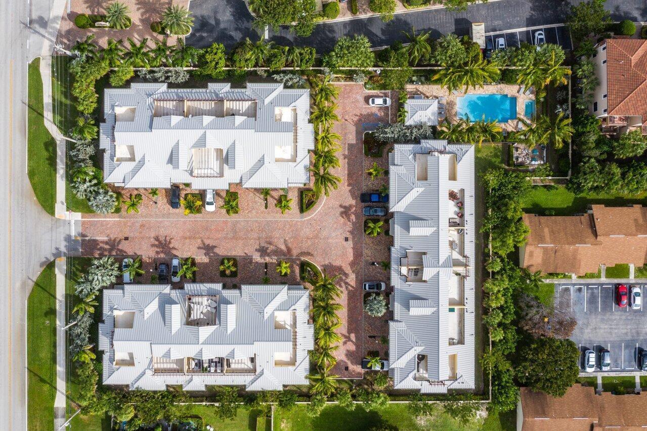 Aerial view of a residential complex with three buildings, a swimming pool, and paved parking — 3770 County Line Road, Tequesta FL 33469, TEQUESTA, FL