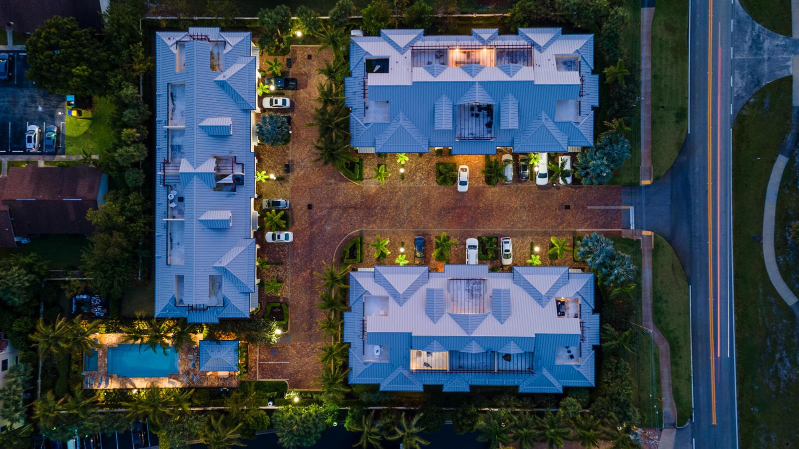 An aerial view shows three residential buildings with metal roofs, a pool, and parking areas — 3770 County Line Road, Tequesta FL 33469, TEQUESTA, FL