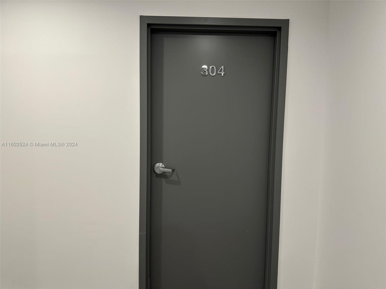 A gray door labeled 304 is set within a plain white wall — 42 NW 27th Ave # 304, Miami FL 33125, MIAMI, FL