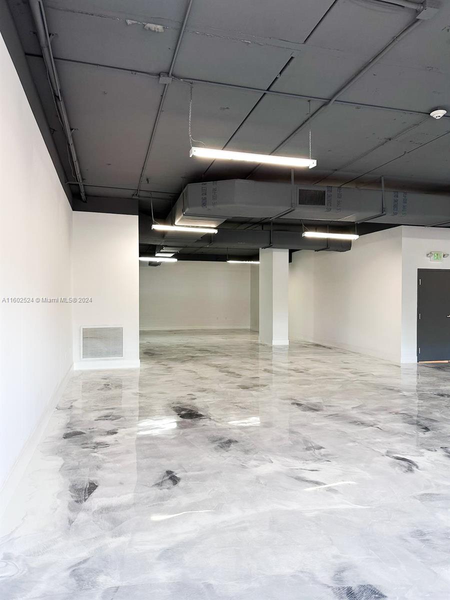 An empty commercial space features a dark ceiling, industrial lighting, and a marbled epoxy floor — 42 NW 27th Ave # 304, Miami FL 33125, MIAMI, FL