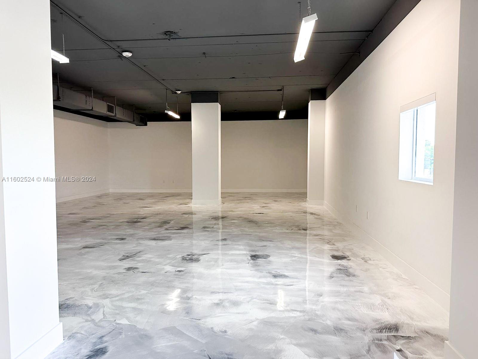 An empty commercial space features a high dark ceiling, white walls, and a marbled floor — 42 NW 27th Ave # 304, Miami FL 33125, MIAMI, FL