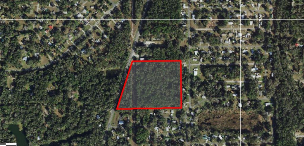 An aerial view shows a rectangular, wooded plot of land outlined in red — 9319 S FLORIDA AVENUE, FLORAL CITY, FL