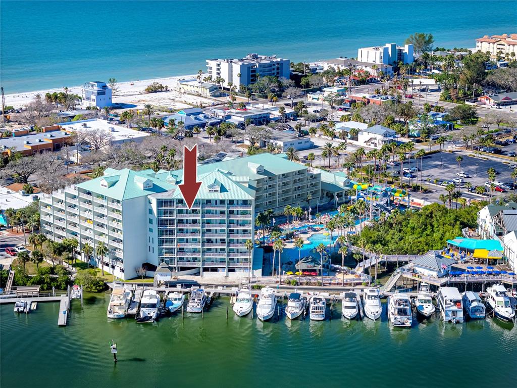 An aerial view shows a multi-story waterfront hotel with a pool and docked boats — 399 2ND STREET UNIT 718, INDIAN ROCKS BEACH, FL