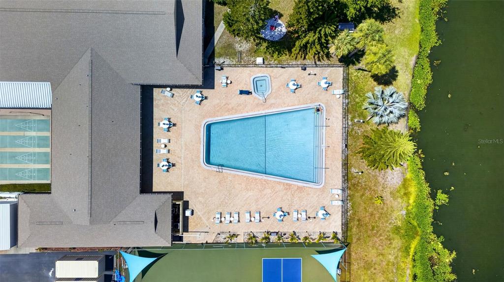 An aerial view shows a swimming pool, patio seating, shuffleboard courts, and a tennis court — 1211 11TH CIRCLE SE, LARGO, FL