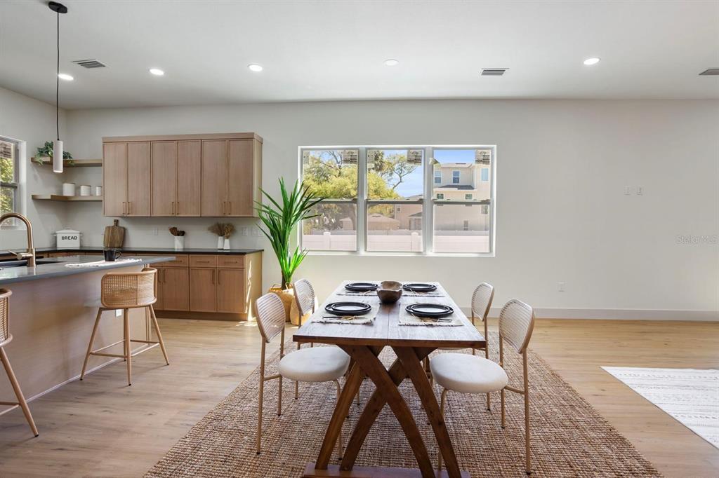 A dining area with a wooden table and chairs sits adjacent to a modern kitchen — 1505 W ARCH STREET UNIT 2, TAMPA, FL