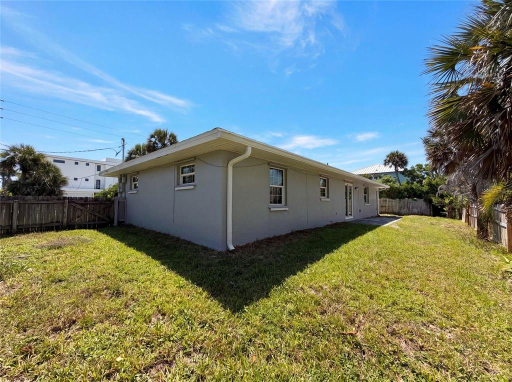 The exterior of a gray, single-story house with a white gutter and a grassy yard — 7820 HIGHWAY A1A, MELBOURNE BEACH, FL