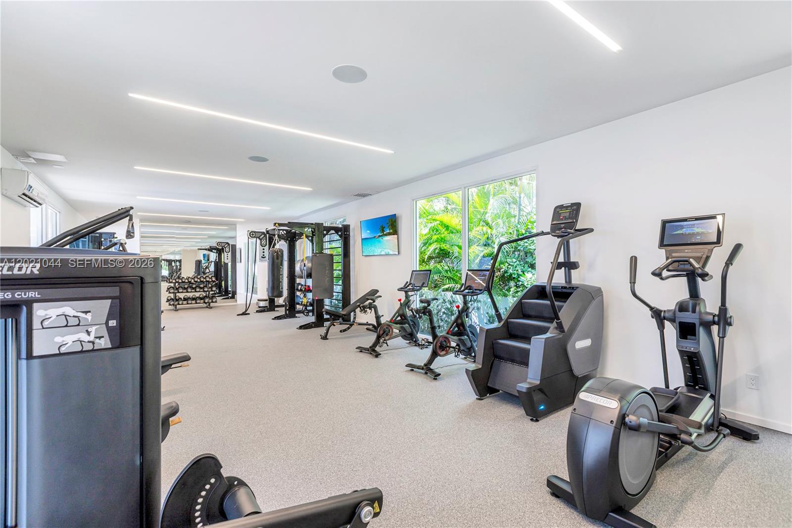 This gym features various exercise machines, large windows, and recessed lighting in a white room — 10250 Collins Avenue # 408, Bal Harbour FL 33154, BAL HARBOUR, FL