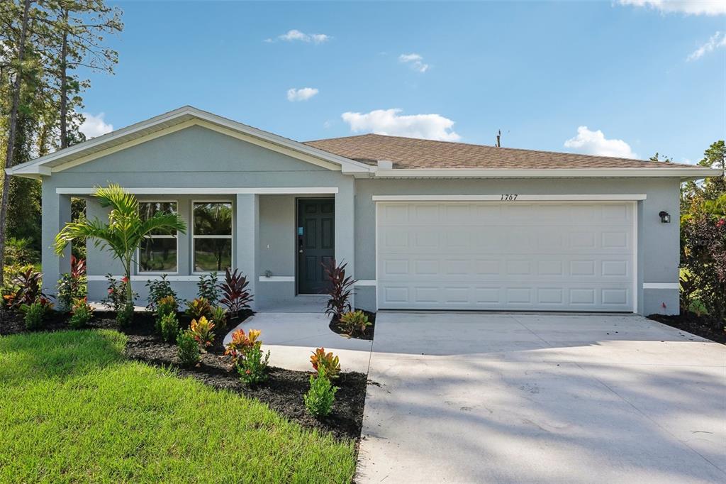 A single-story house with a gray exterior, a two-car garage, and a landscaped front yard — 13378 CANYON SWALLOW ROAD, BROOKSVILLE, FL