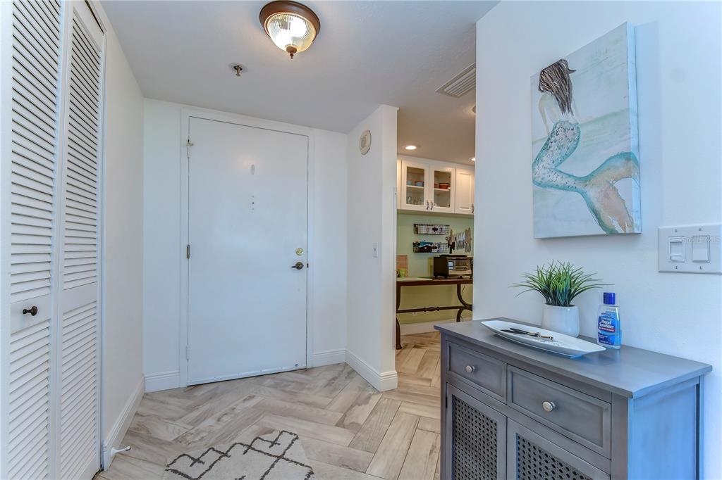 An entryway features a white door, a gray console table, and light wood-look tile flooring — 6322 PALMA DEL MAR BOULEVARD S UNIT 505, ST PETERSBURG, FL