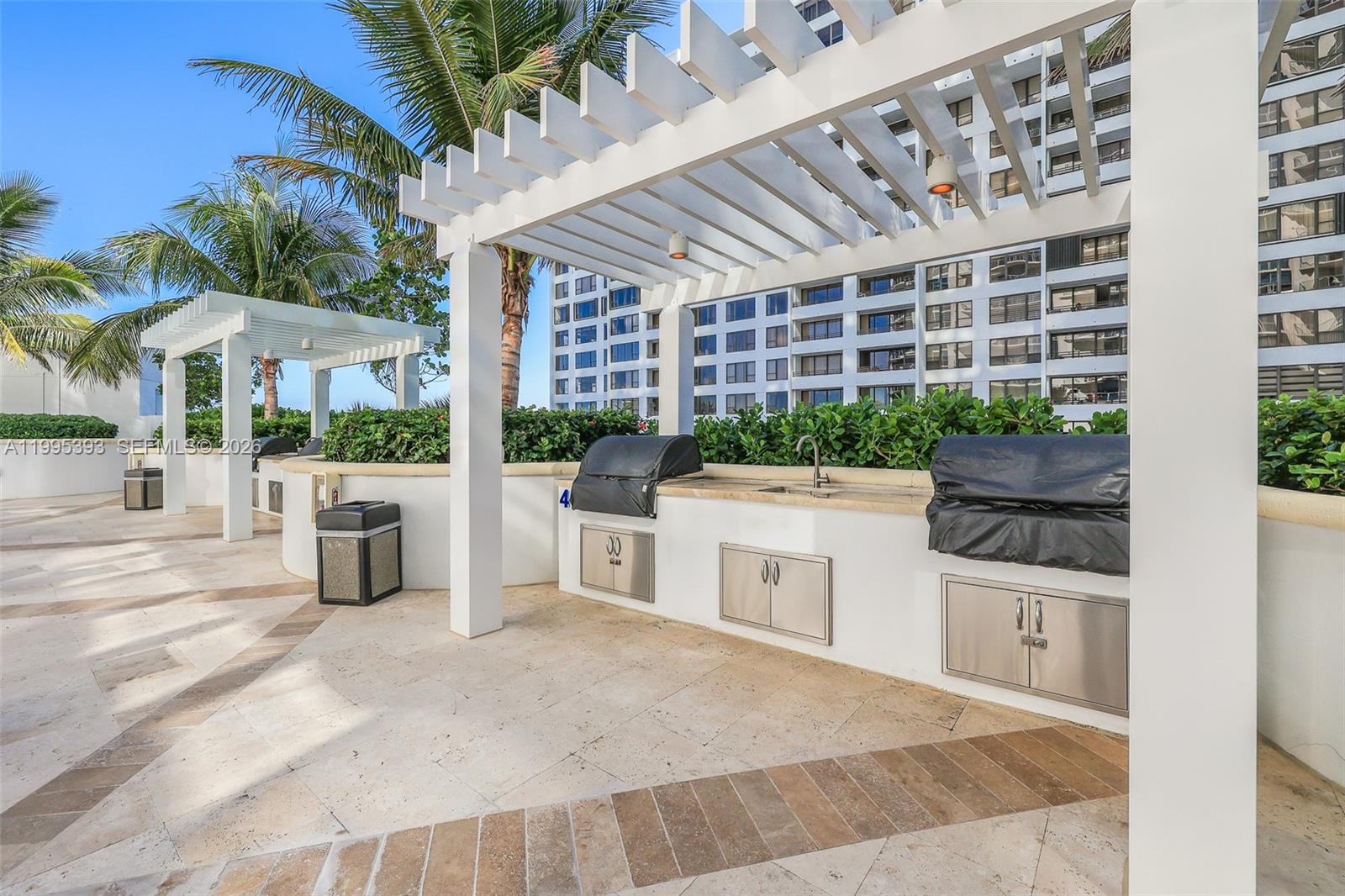 An outdoor kitchen area features two covered grills, a sink, and a white pergola — 3101 S Ocean Dr # 1904, Hollywood FL 33019, HOLLYWOOD, FL