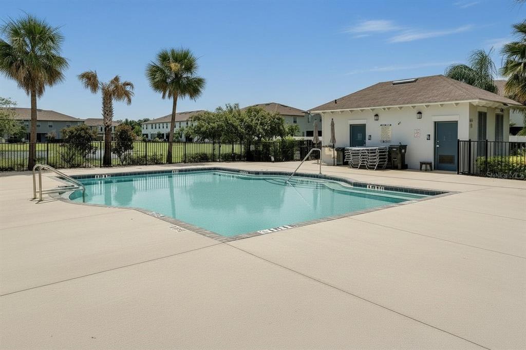 A swimming pool with a concrete deck and a small building under a clear sky — 724 ROYAL EMPRESS DRIVE, RUSKIN, FL