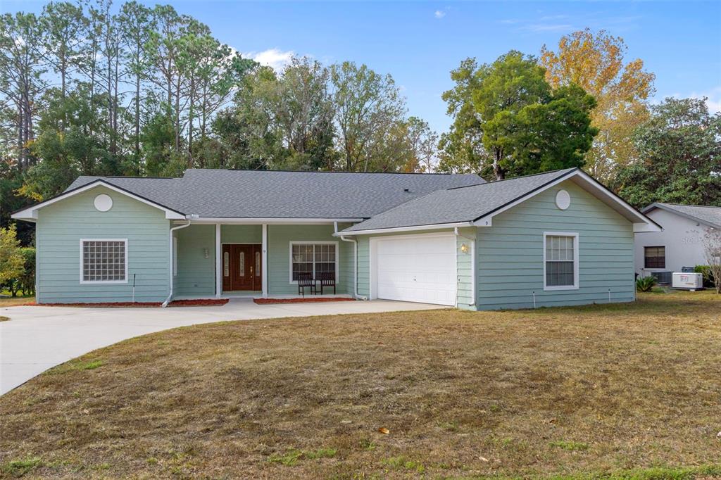 A single-story house with light green siding, a two-car garage, and a concrete driveway — 9 FOXGREEN COURT, HOMOSASSA, FL