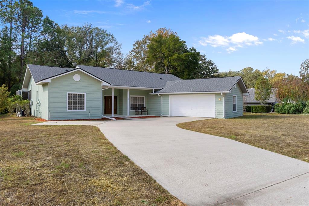 A light green single-story house with a gray roof and a concrete driveway — 9 FOXGREEN COURT, HOMOSASSA, FL