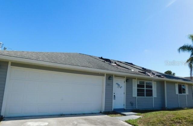 A single-story house with gray siding, a two-car garage, and visible roof damage — 705 SW 9TH COURT, CAPE CORAL, FL