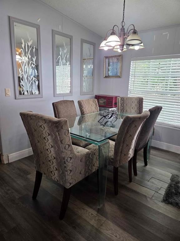 A dining room features a glass-top table, six upholstered chairs, three wall mirrors, and a chandelier — 1400 ROBINSON CIRCLE UNIT 111, FORT MEADE, FL