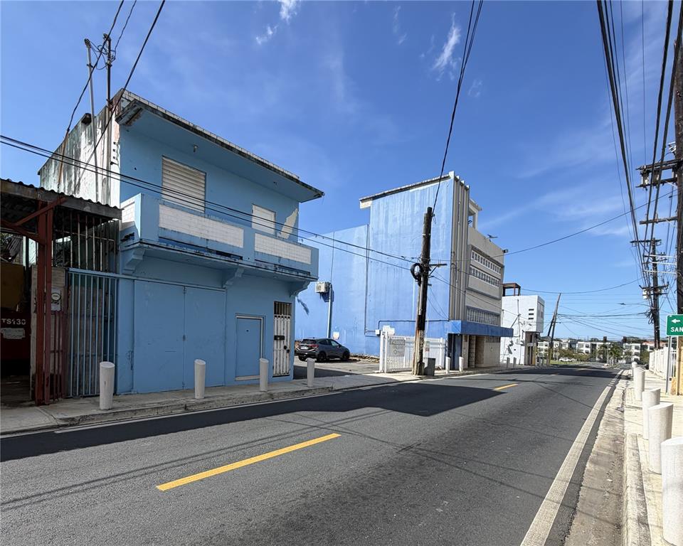 A street view of two blue commercial buildings with a parking area between them — 839 C. HIRAM GONZÁLEZ, BAYAMON, PR