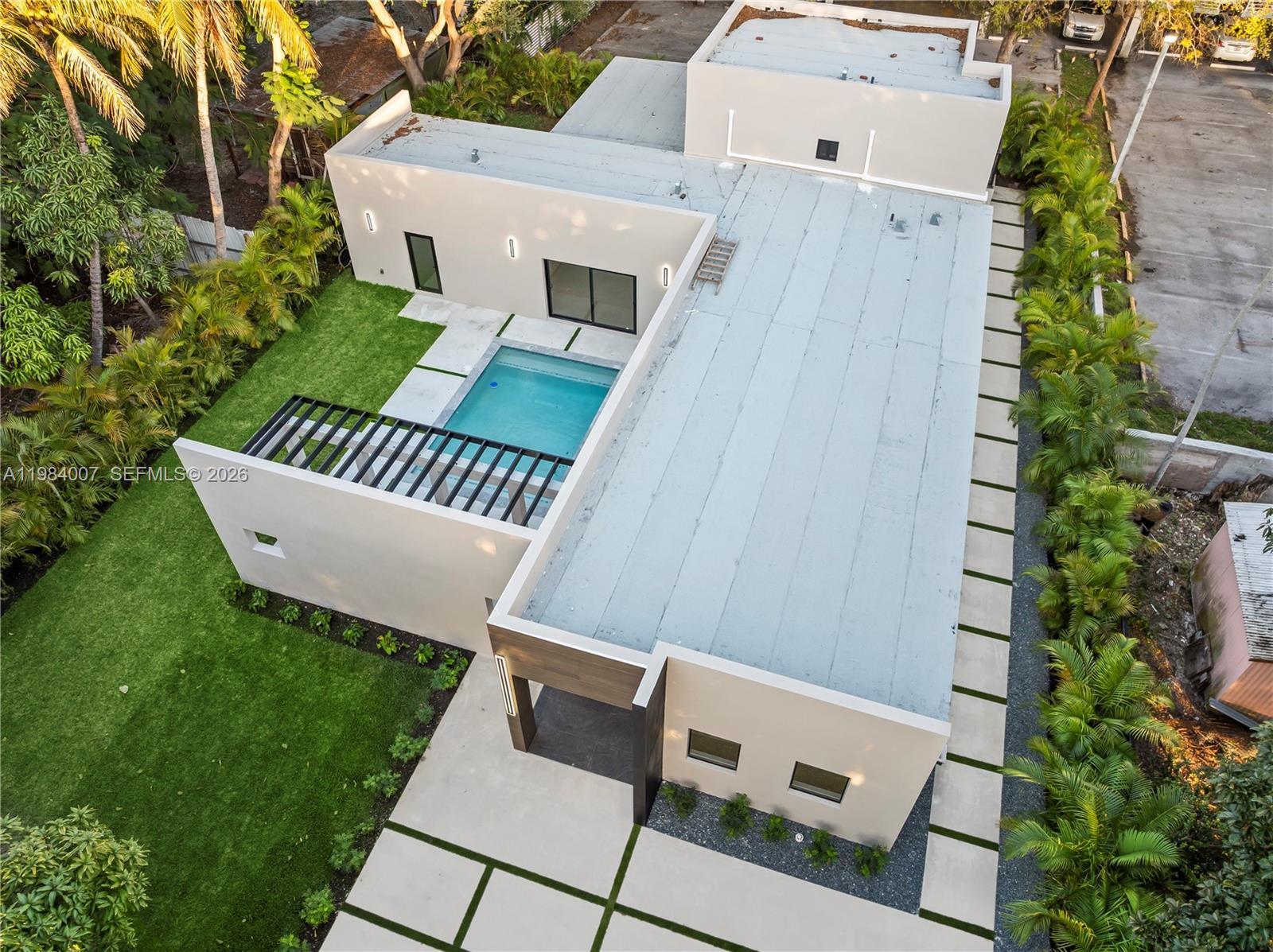 An aerial view shows a modern house with a flat roof, swimming pool, and courtyard — 12335 Griffing Blvd, North Miami FL 33161, NORTH MIAMI, FL