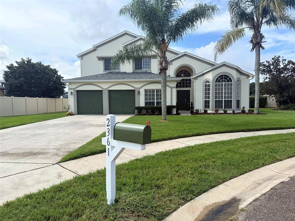 A two-story house with a green garage, a palm tree, and a mailbox in front — 2361 MID PINE COURT, OVIEDO, FL