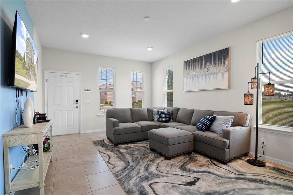 A living room features a gray sectional sofa, a patterned area rug, and a television — 294 ABERDEEN STREET, DAVENPORT, FL