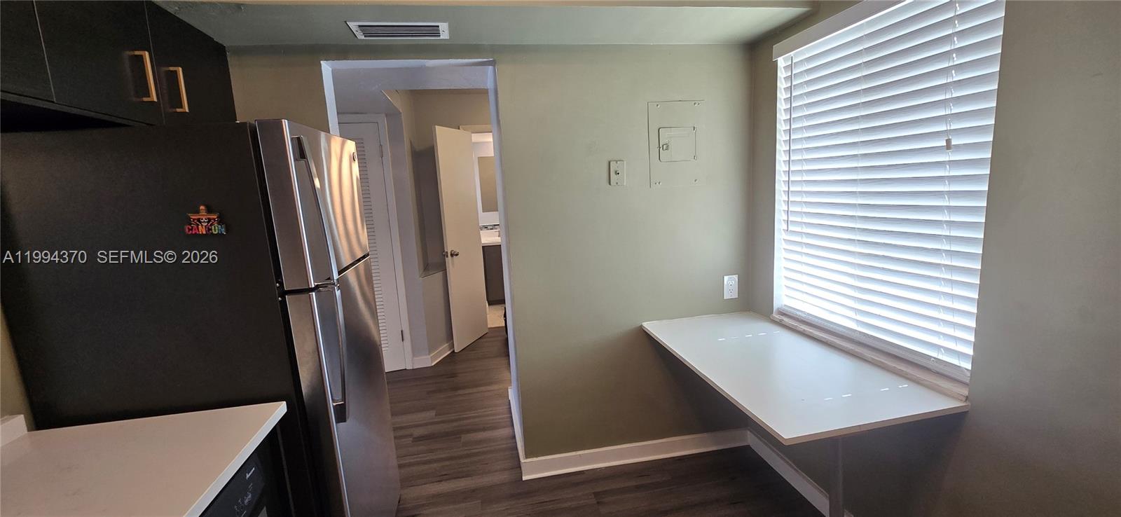 A kitchen area features a refrigerator, a wall-mounted desk, and a doorway leading to a bathroom — 1201 NE 191st St # G306, Miami FL 33179, MIAMI, FL