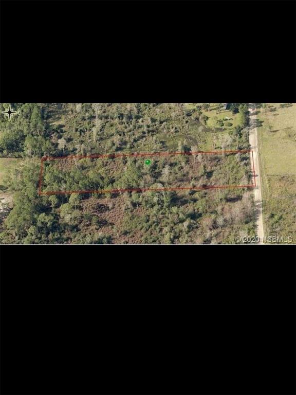 An aerial view shows a rectangular plot of land outlined in red next to a road — 4150 QUAIL NEST LANE, NEW SMYRNA BEACH, FL