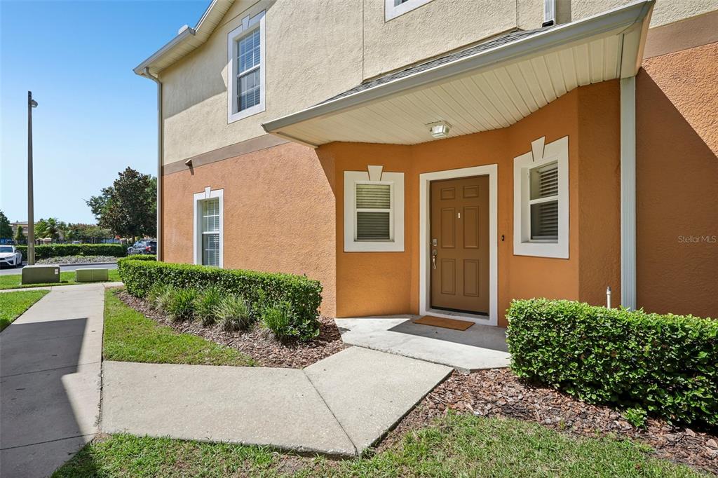 The exterior of a two-story tan and orange building features a brown front door — 4244 BIRCH POND LOOP, LAKELAND, FL