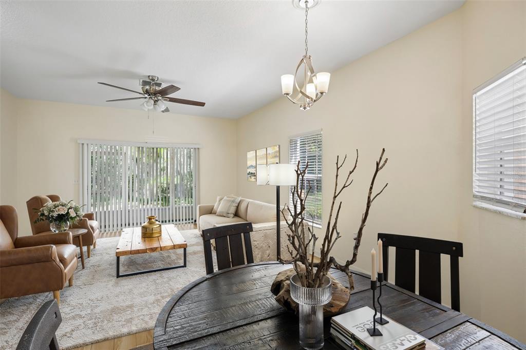 A living and dining area features a round wooden table, leather armchairs, and a sofa — 4244 BIRCH POND LOOP, LAKELAND, FL