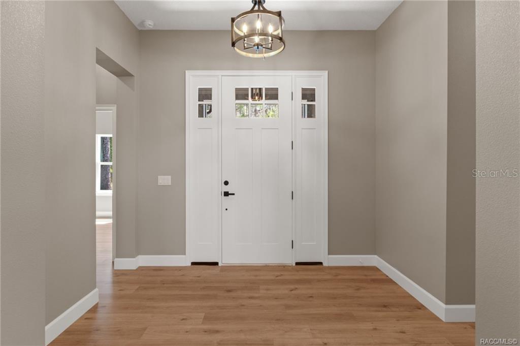 A foyer with light wood flooring, beige walls, and a white front door with sidelights — 4530 S FLORIDA AVENUE, INVERNESS, FL