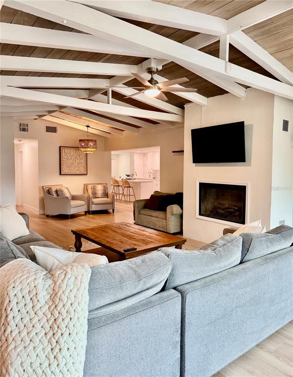 A living room features a vaulted wood-beam ceiling, a fireplace, and a large sectional sofa — 156 N BLVD OF THE PRESIDENTS, SARASOTA, FL