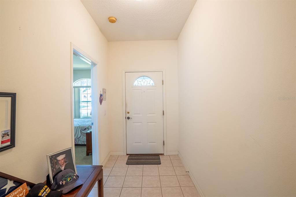 A tiled entryway features a white front door and an adjacent doorway leading to a bedroom — 7 ARBOR TRACE UNIT 2, PALM COAST, FL