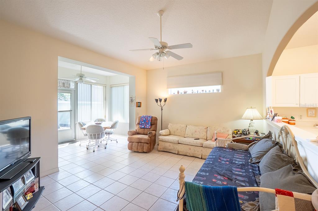 A living room with tile flooring, a ceiling fan, and an adjacent dining area — 7 ARBOR TRACE UNIT 2, PALM COAST, FL