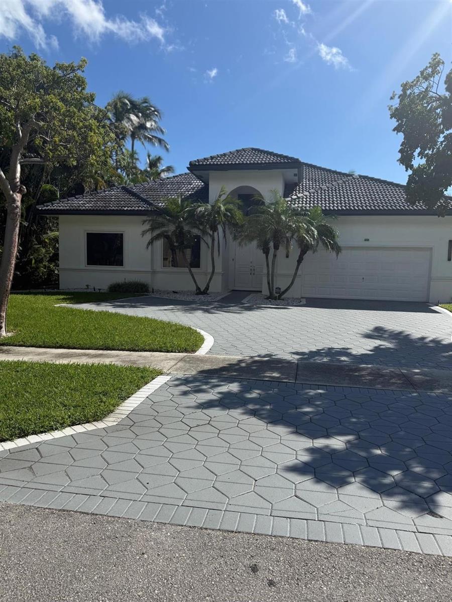 A single-story house with a gray tiled roof, white stucco walls, and a patterned driveway — 830 Bailey Street, Boca Raton FL 33487, BOCA RATON, FL