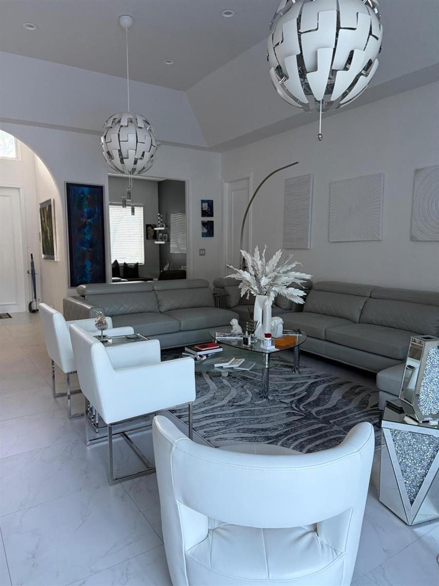 A modern living room features gray leather sofas, white armchairs, and two spherical pendant lights — 830 Bailey Street, Boca Raton FL 33487, BOCA RATON, FL