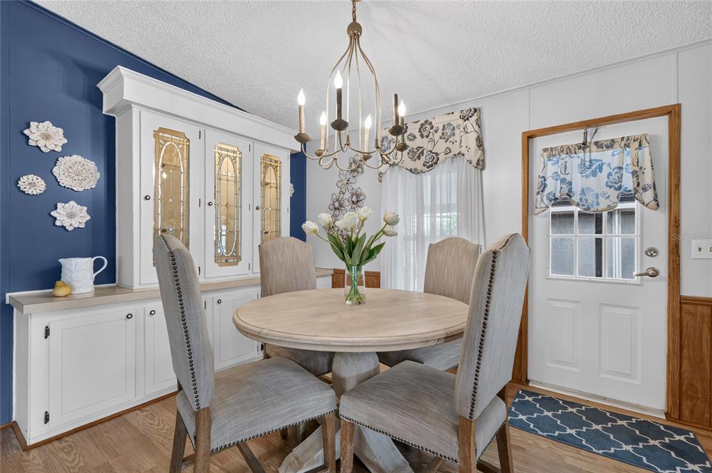 A dining room features a round wooden table, four upholstered chairs, and a white hutch — 572 TAMMI DRIVE, LEESBURG, FL