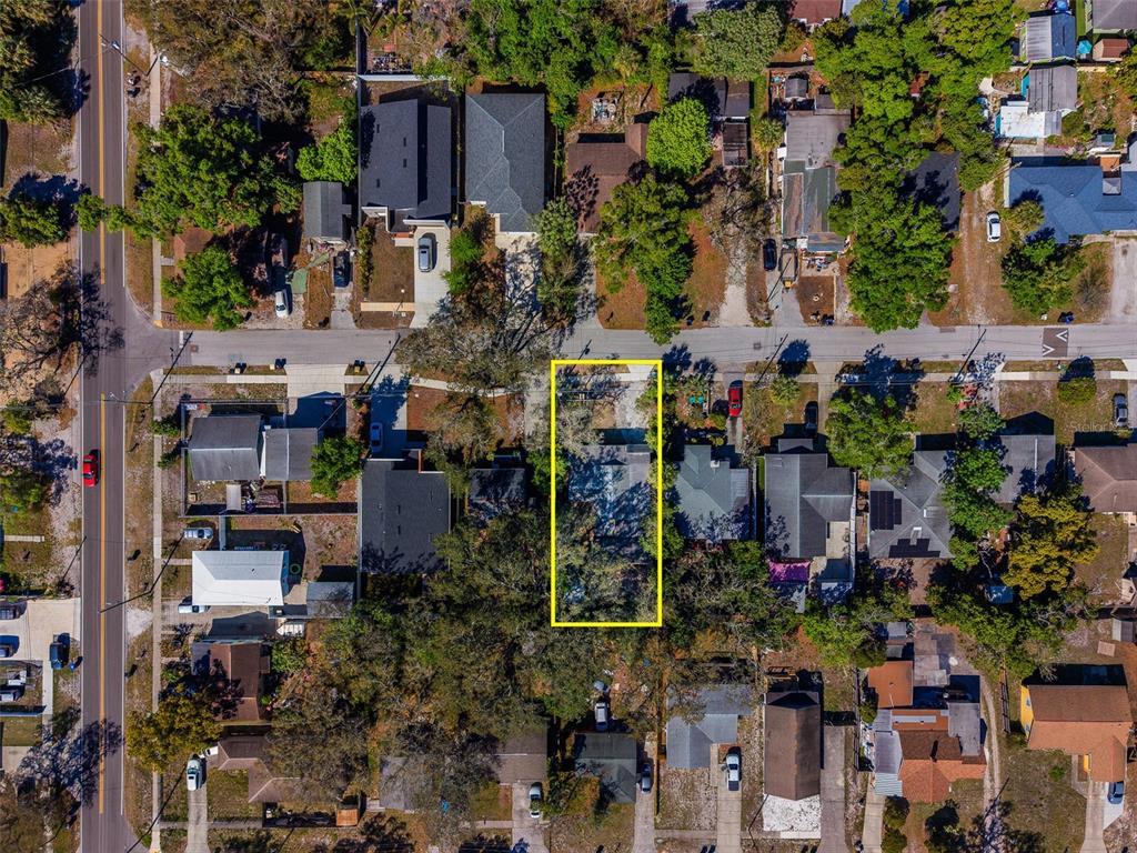 An aerial view shows a residential property highlighted by a yellow rectangle among neighborhood houses — 1579 S WASHINGTON AVENUE, CLEARWATER, FL