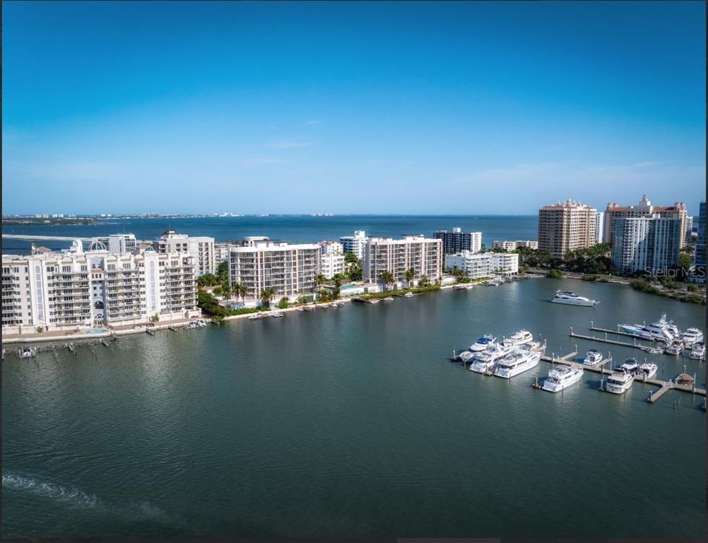 An aerial view of a waterfront residential area with multiple apartment buildings and docked boats — 550 GOLDEN GATE POINT UNIT 503, SARASOTA, FL