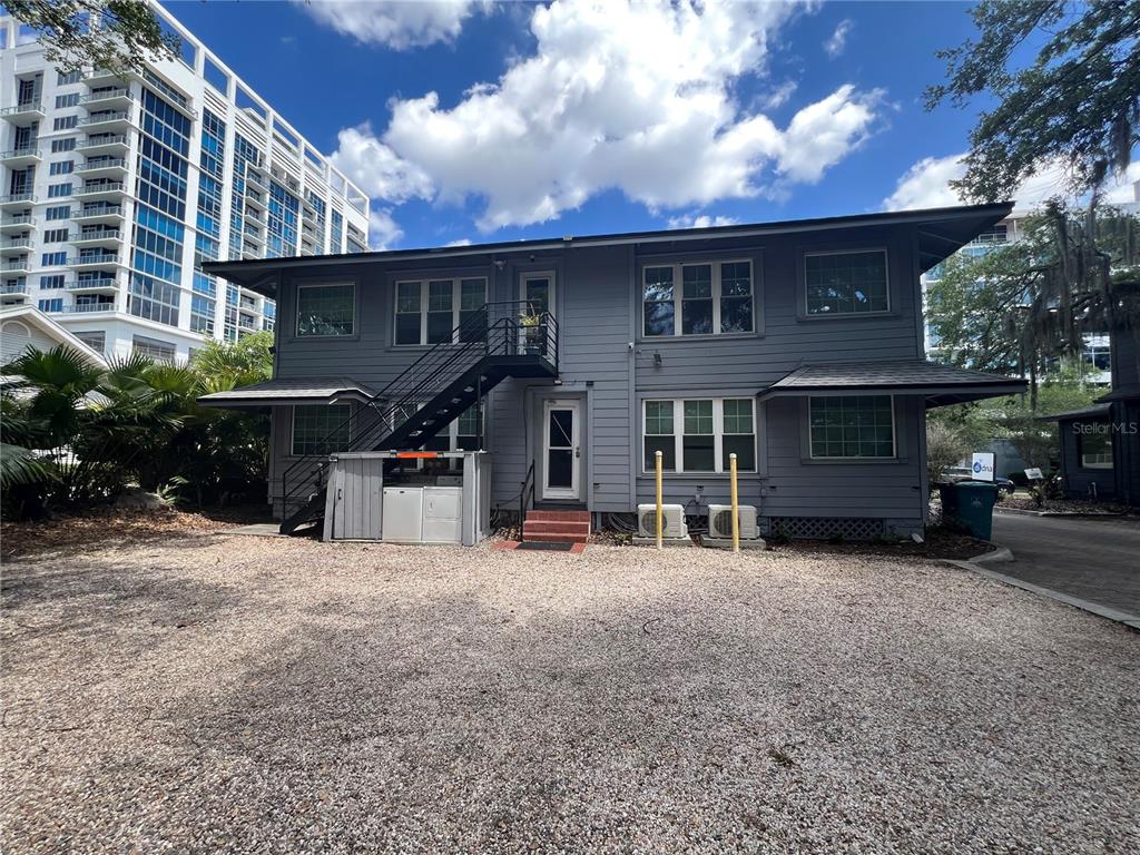 A small kitchen features dark wood cabinets, white appliances, and wood-look flooring — 510 E JACKSON ST UNIT 3, ORLANDO, FL