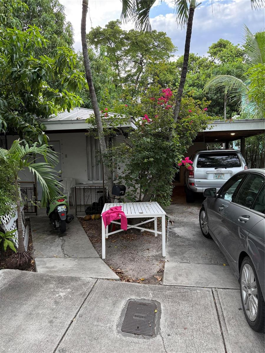 A house exterior features a driveway with two parked cars, a white table, and palm trees — 414 Virginia Street, Key West FL 33040, KEY WEST, FL